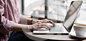 Woman working on laptop computer panoramic banner, female hands typing keyboard closeup, student girl using laptop at cafe