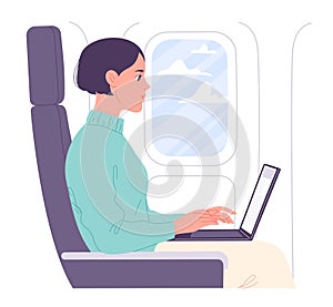 Woman working on laptop in flight cabin