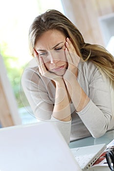 Woman working on laptop getting tired photo