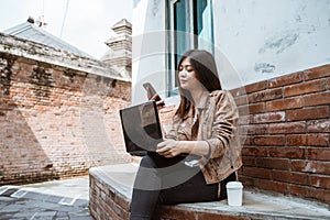 Woman working with laptop and her mobile phone