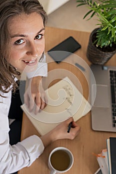 Woman working on laptop at home office while drinling coffee. Web conection