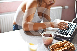 Woman working with laptop in kitchen