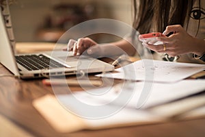 Woman working on laptop and mobile phone