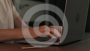 Woman is working on laptop notebook at home office. Close-up of female hands typing on laptop keyboard. Businesswoman