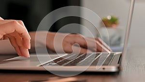 Woman is working on laptop notebook at home office. Close-up of female hands typing on laptop keyboard. Businesswoman