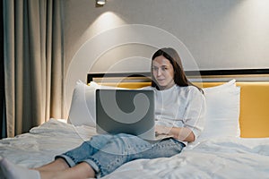 Woman Working on Laptop While Relaxing in Bed