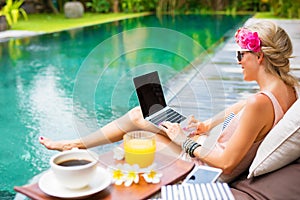 Una mujer en negocios sobre el computadora portátil mientras de acuerdo a piscina 