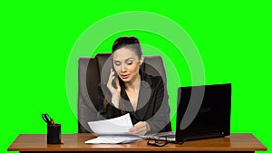 Woman working on a laptop then answers the call by mobile phonen, suprised and very happy. Green screen