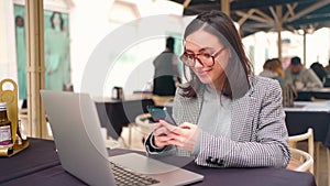 Woman working with laptop use smartphone sitting Street Cafe