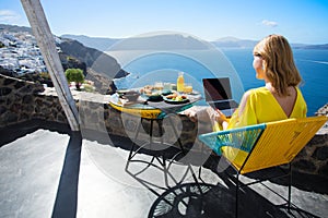 Woman working with laptop while on vacation in Mediterranean