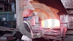 Woman working with Liquid molten metal melted in furnace at metallurgical plant.