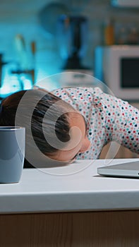 Woman working at night falling asleep on desk