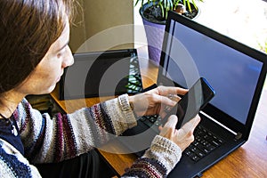 Woman working in office with digital tablet and notebook, writing and typing