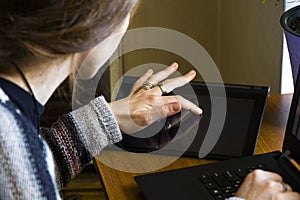 Woman working in office with digital tablet and notebook, writing and typing