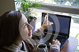 Woman working in office with digital tablet and notebook, writing and typing