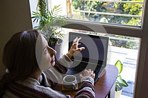 Woman working in office with digital tablet and notebook, writing and typing