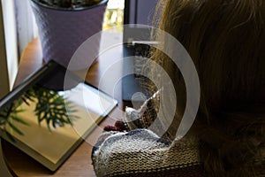 Woman working in office with digital tablet and notebook, writing and typing