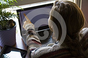 Woman working in office with digital tablet and notebook, writing and typing