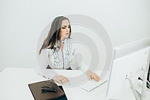 Woman working in office, sitting at desk, using computer