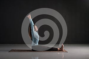 Woman working out a doing yoga or pilates exercise in Dandasana