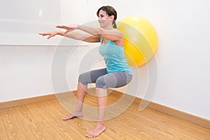 Woman working out with exercise ball in gym. Pilates woman doing exercises in the gym workout room with fitness ball.