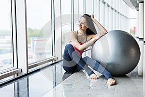 Woman working out with exercise ball in gym. Pilates woman doing exercises in the gym workout room with fitness ball. Fitness woma