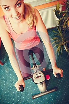 Woman working out on exercise bike. Fitness.