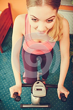 Woman working out on exercise bike. Fitness.