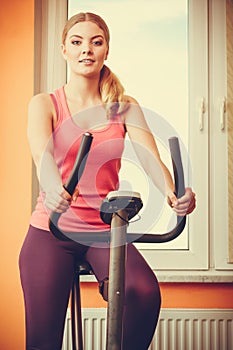Woman working out on exercise bike. Fitness.