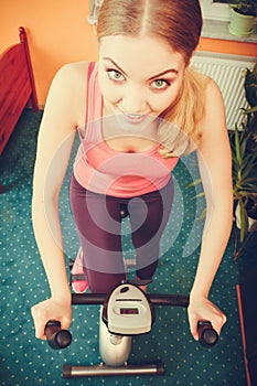 Woman working out on exercise bike. Fitness.