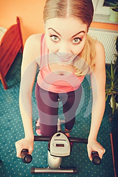 Woman working out on exercise bike. Fitness.