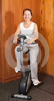 Woman working out on exercycle at home