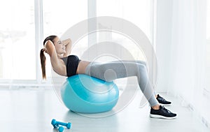 Woman working out with fitness ball in gym