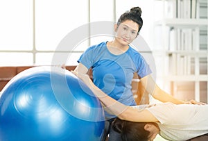 Woman working out with fitness ball of sportswomen practicing yoga. Stretching using fitness ball at home