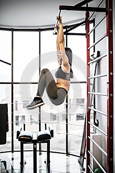 Woman working out in fitness on press treiner on exercises at gym