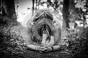 Woman working out outdoors, performing planking exercice in the woods