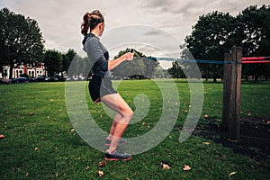 Woman working out with resistance band in the park