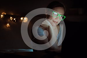 Woman working overtime on laptop computer late at night