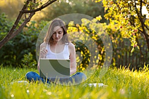 Woman working at the park with laptop