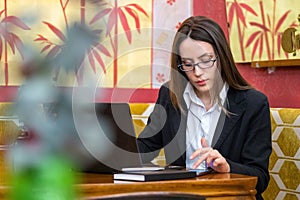 Woman working on the PC and on the phone