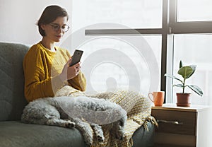 Woman working with phone at home quarantine.