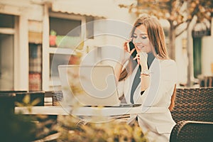 Woman working with a phone and laptop