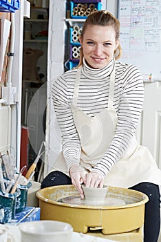 Woman Working At Pottery Wheel In Studio