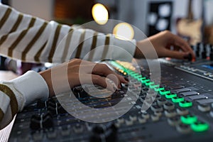 Woman working with professional mixing console in modern radio studio, closeup