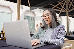 Woman working on remote from outdoor cafe