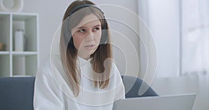 Woman is working remotely by internet. Happy young business woman wears headset talks to web camera making distance