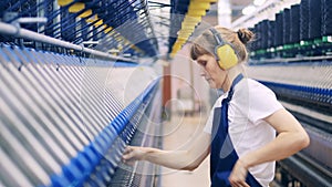 A woman is working with threads in the textile factory unit. textile production, textile industry, textile manufacture