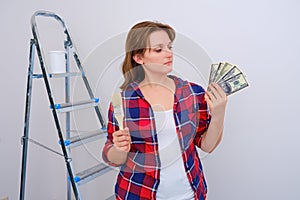 Woman working to repair the apartment with payment in us dollars. Money for the repair of new house