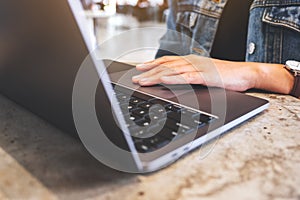 A woman working and touching on laptop computer touchpad on the table