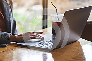 A woman working and touching on laptop computer touchpad on the table